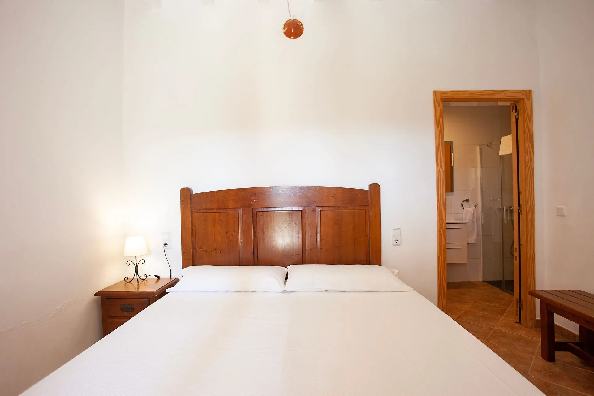 A second bedroom, a wide bed and a bedside table