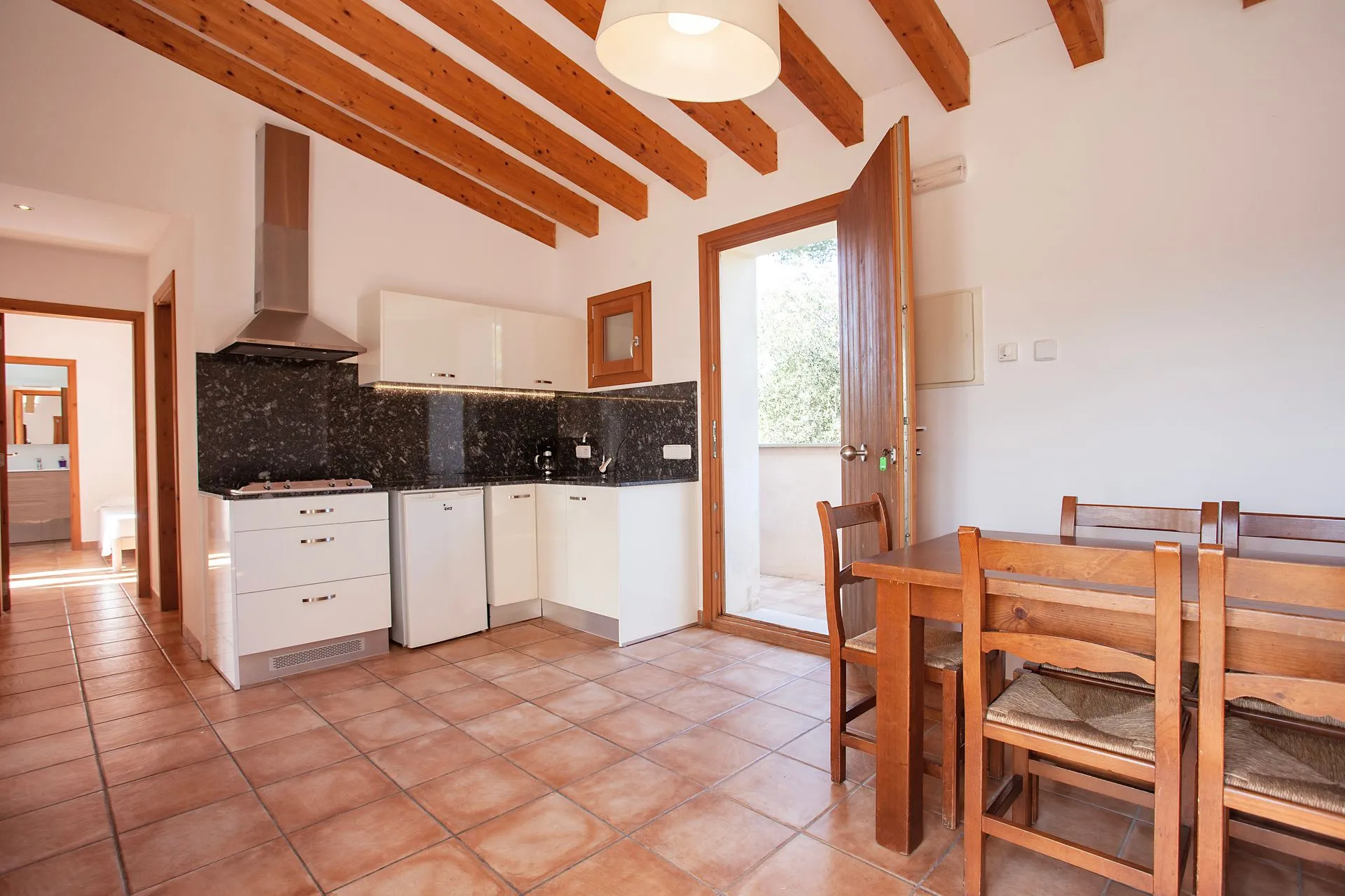 A kitchen with a table and chairs, fitted to a rustic finca interior